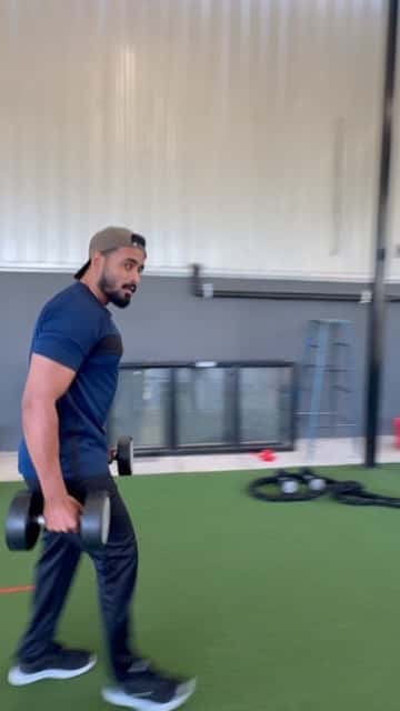 FOMO Training coach demonstrating a dumbbell carry