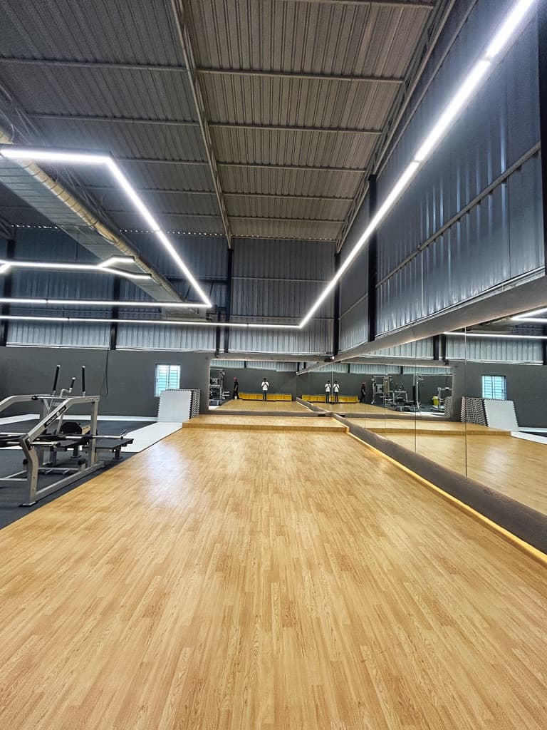 Mirrored wooden-floor group class studio at FOMO Training, Carmelaram